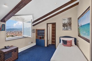 A room with a large window, a bed with an American flag pillow, a bookshelf, and a poster of The Beatles. - AMORE RENTALS - Villa Imma with Swimming Pool and Sea View (Castellammare di Stabia)