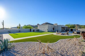 A modern house with a patio, outdoor seating, and a well-maintained lawn. - Tonto Casita – Luxury Foothills Home w/ Mtn Views (Apache Junction)
