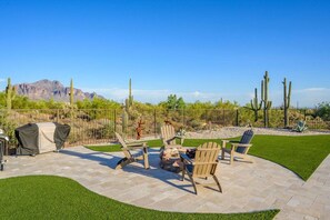 An outdoor patio with a barbecue grill, seating area, and a view of a desert landscape with cacti and mountains. - Tonto Casita – Luxury Foothills Home w/ Mtn Views (Apache Junction)