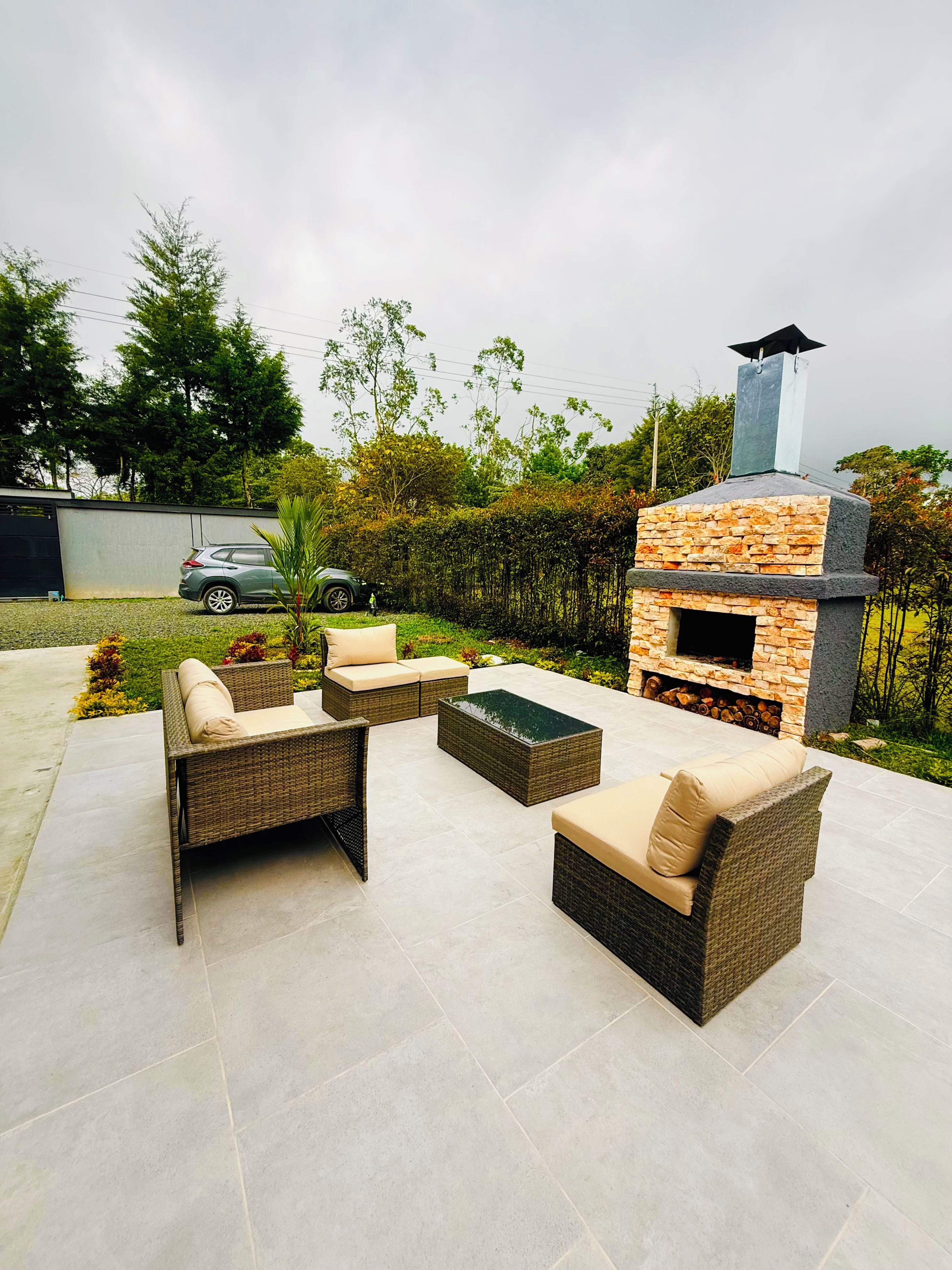 An outdoor patio with wicker furniture and a stone-built barbecue area.