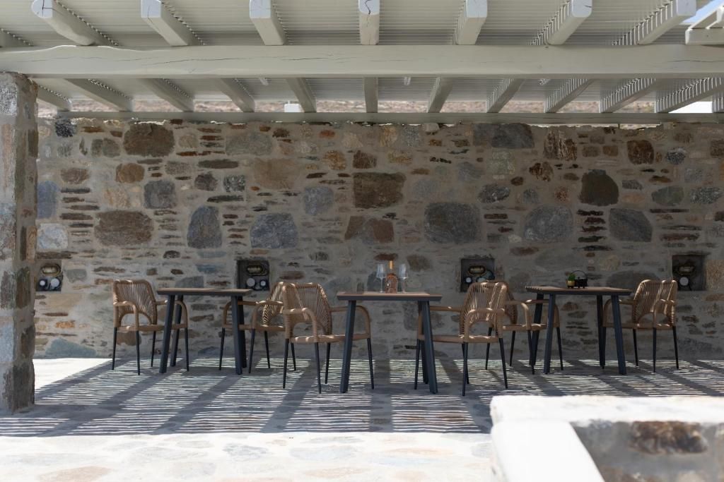 An outdoor seating area with stone walls and wooden furniture.