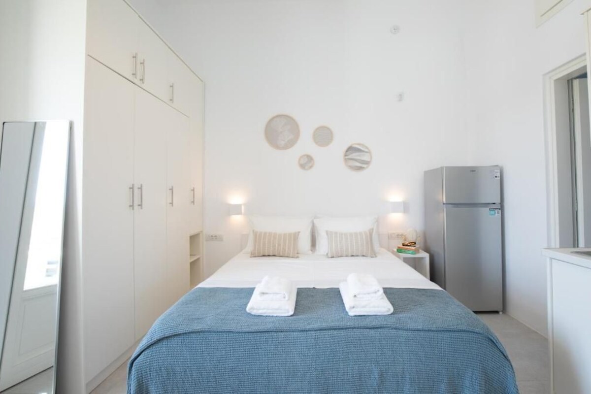 Una habitación de hotel moderna con cama, kitchenette y armario.