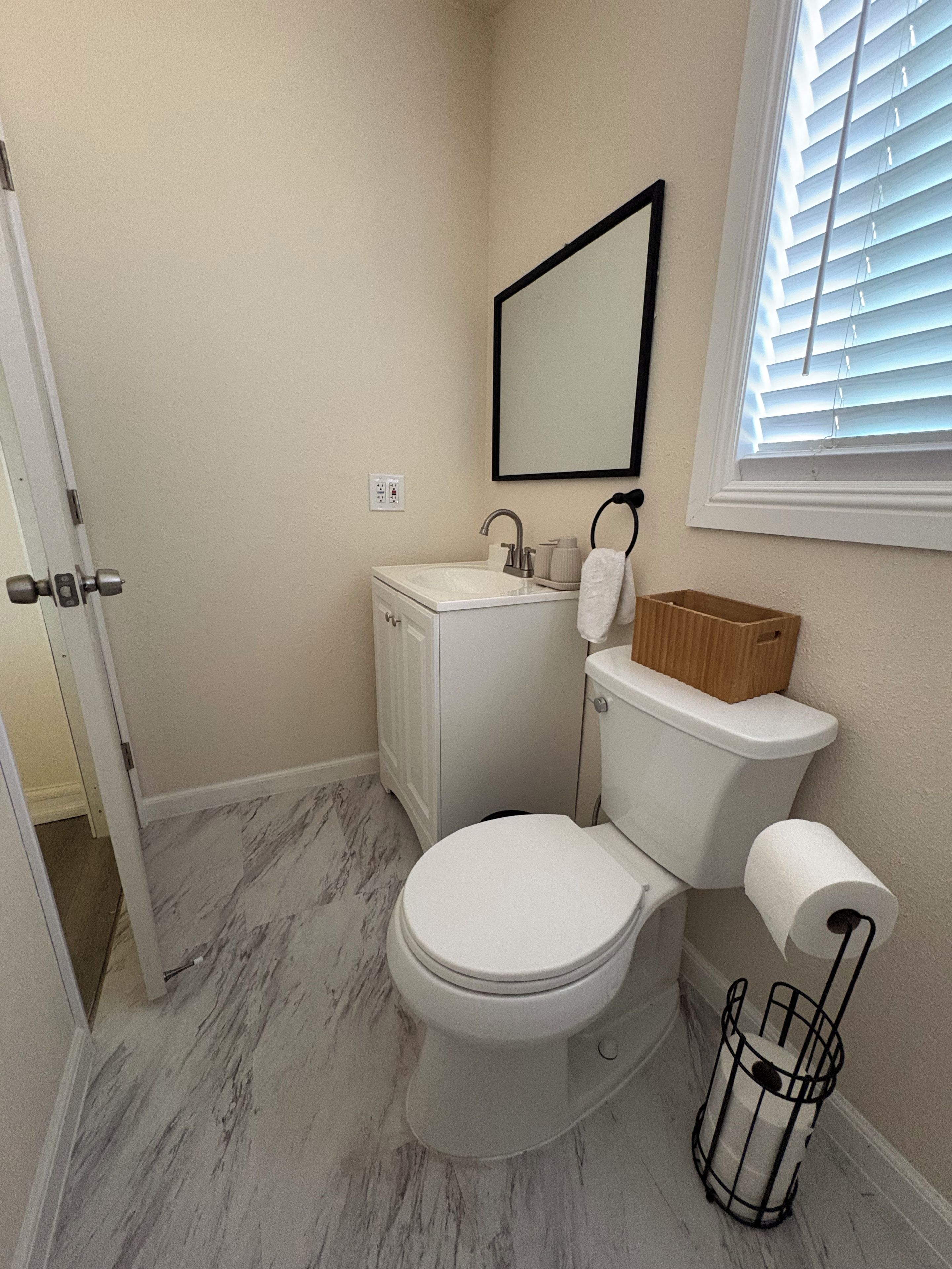 Une salle de bain avec des toilettes, un lavabo et un miroir.