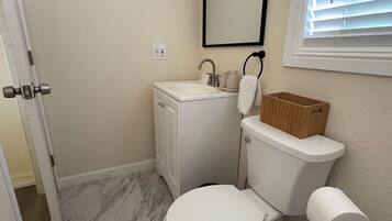 Une salle de bain avec des toilettes, un lavabo et un miroir.