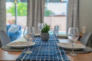 A dining table with two wine glasses, plates, and a placemat. - Spacious 4BDR Tempe Getaway Hot Tub + Pool 5 Min to ASU (Tempe)