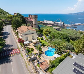 Ein Küsteneigentum mit Schwimmbad, einem Turm und einem Yachthafen.