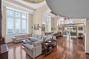 Ein geräumiges Wohnzimmer mit einer großen Eckcouch, einem Couchtisch und einem Essbereich mit Stühlen und Tisch.