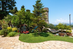 A garden with a stone tower, a playground, and a paved area. - Villa Imma in Castellammare di Stabia (Castellammare di Stabia)