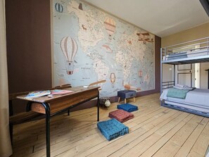 A room with a bunk bed, a desk with books, a map on the wall, and colorful cushions. - "The Barn" - Charming stay in the Loire valley close to castles and Beauval zoo (Saint-Aignan)