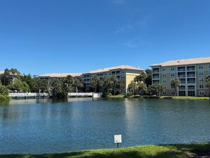 A hotel with a lake view, multiple balconies, and a bridge in the background. - Sheraton Vistana Villages Spacious 1 BR Premium Villa Orlando Fl. (Orlando)