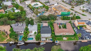 Luchtbeeld van een woongebied met huizen, een zwembad en een jachthaven.
