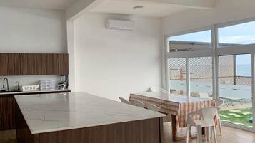Una cocina moderna con una isla de madera, un comedor con vistas y un ventanal grande.