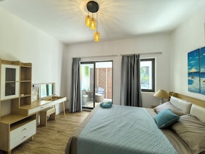 A bedroom with a bed, a desk, a chair, a window, and a view of the outdoors. - Villa Palmito: 3-room Villa with a Private Pool in Trou aux Biches (Trou aux Biches)