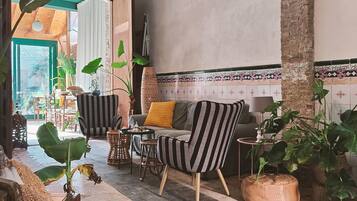 Un intérieur chaleureux avec un canapé à rayures, un banc rembourré et un luminaire suspendu.