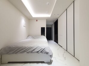 Una camera da letto moderna con un letto, un lucernario e un armadio.