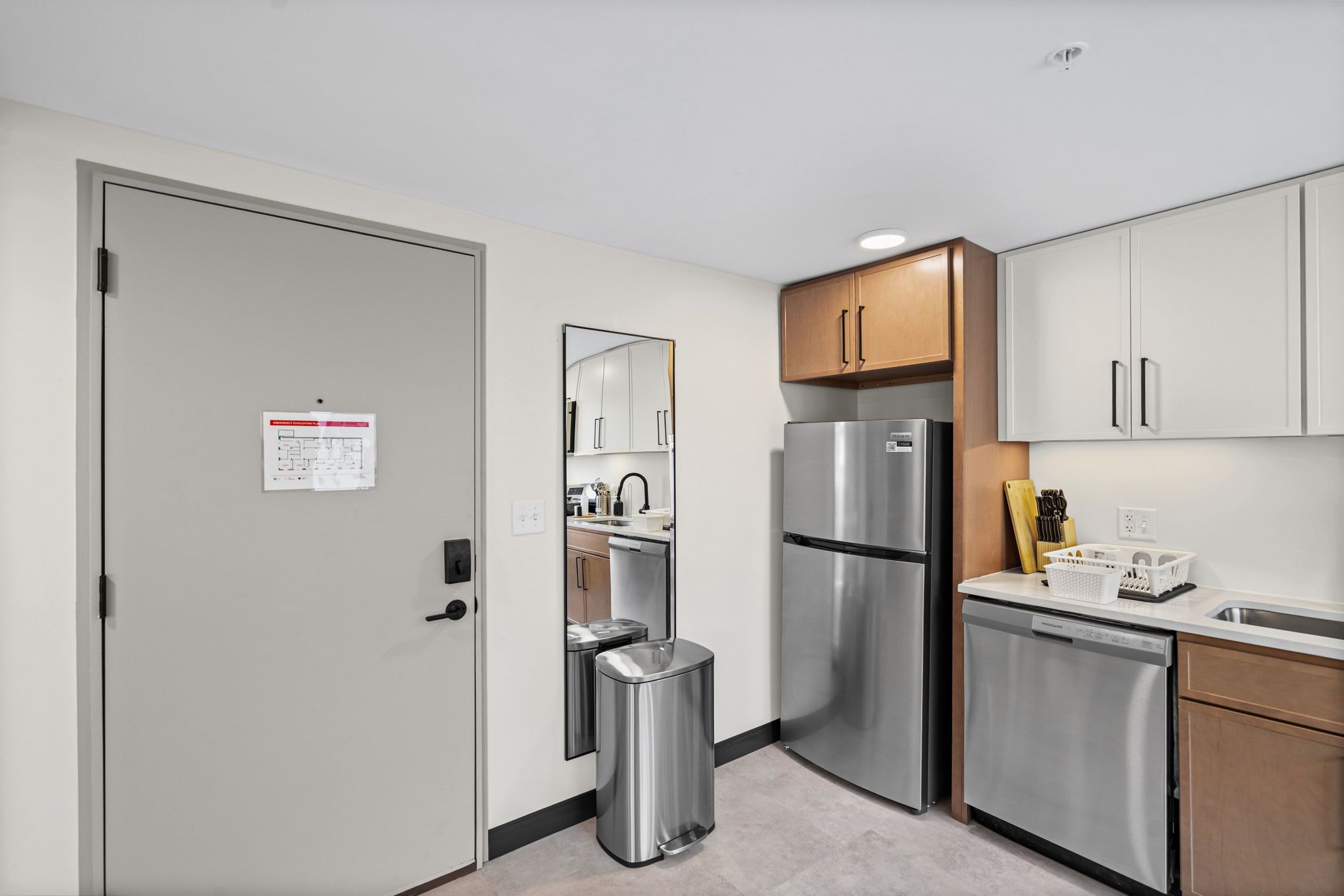 A modern kitchen with stainless steel appliances, wooden cabinets, and a built-in dishwasher.