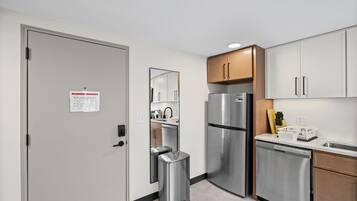 A modern kitchen with stainless steel appliances, wooden cabinets, and a built-in dishwasher.