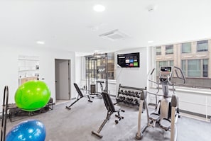 Ett modernt gym med konditionsmaskiner, styrketräningsmaskiner och träningsbollar.