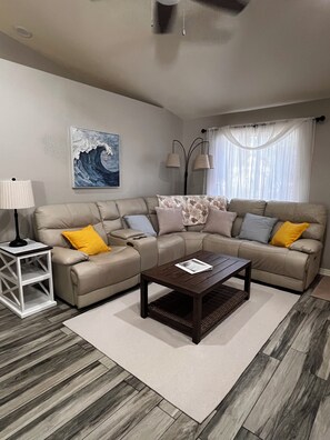 A living room with a sofa, a coffee table, a lamp, and a painting on the wall. - Peaceful Palms at Bonita Springs. 10 minutes to the beach and Downtown Shopping (Bonita Springs)