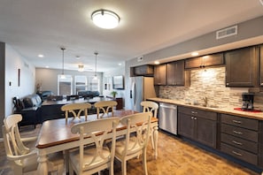 A modern kitchen with dark cabinets, a stainless steel refrigerator, and a tiled backsplash. - Water Toys, Reunion LOZ, Hot Tub, Dock with boat slips (Linn Creek)