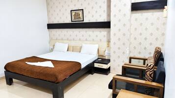 A bedroom with a bed, bedside tables, a nightstand, and a chair.