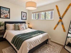 A bedroom with a bed, a window, a ski rack, and wall art. - Peaceful 4-bedroom house in South Lake Tahoe perfect for families (South Lake Tahoe)