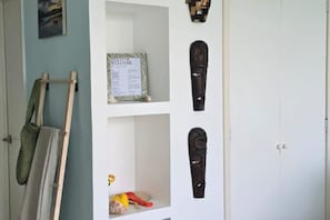 A room with a white door, a framed welcome sign, and two shelves with decorative items. - 🌊 Oceanfront in Nuevo Vallarta | Infinity Pool (Nuevo Nayarit)