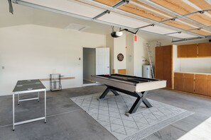 Ein großzügiger Innenbereich mit Billardtisch, Dartscheibe und Poolbillard.