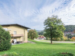 A residential building with a balcony, a lawn, and a view of a village in the background. - Apartment Stephi by Interhome (Neukirchen beim Heiligen Blut)