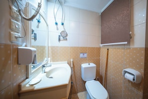 A bathroom with a sink, toilet, and hand dryer. - multazam Hotel (Makkah)