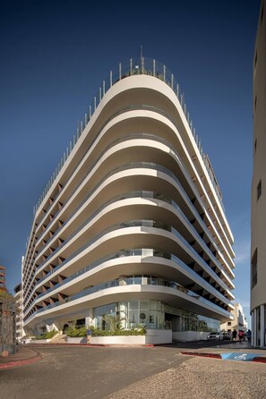 A modern multi-story building with a curved facade and balconies. - corazone cabo  3-bedroom condo with jacuzzi in superb Cabo San Lucas (Cabo San Lucas)