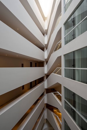 A multi-level interior with a central atrium, glass railings, and a modern architectural design. - corazone cabo  3-bedroom condo with jacuzzi in superb Cabo San Lucas (Cabo San Lucas)