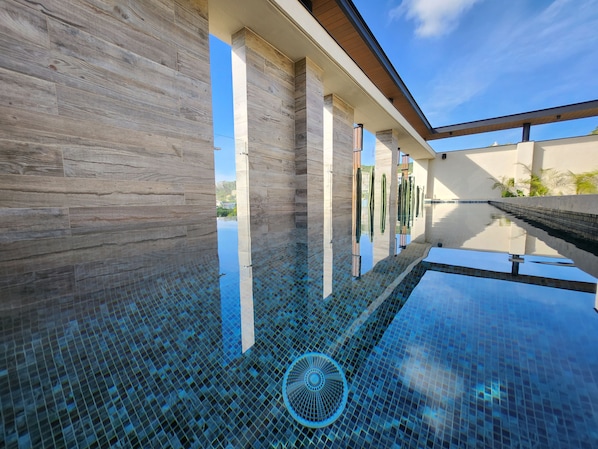 A modern pool with a clear view of the sky and surrounding buildings. - Ameth- Apartments w/ Rooftop Pool & Gym (Cabo San Lucas)
