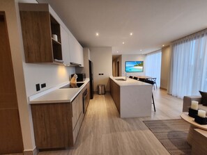 Eine moderne Küche mit Holzausstattung, einer Mittelinsel und einem großen Fenster mit Meerblick.