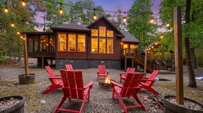 A wooden cabin with a deck, outdoor seating, and a fire pit. - Classic! Away From It All! Hot Tub-Firepit-Arcade! (Broken Bow)