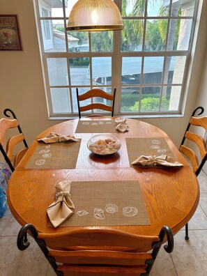 A dining table set with placemats, a bowl of snacks, and a decorative lamp. - Escape Winter in Fort Myers Furnished 2BR/2BA Colonial Country Club (Fort Myers)