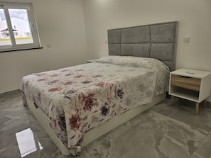 A bedroom with a bed, a nightstand, a window, and a view of the outside. - 1-Bedroom Apartment (Armação de Pêra)