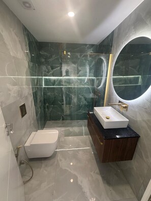 A modern bathroom with a built-in shower, a standalone toilet, and a vanity with a sink. - 1-Bedroom Apartment (Armação de Pêra)
