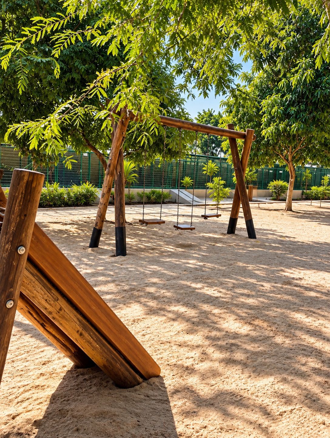 Un parque infantil con columpios y arena.