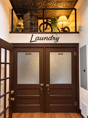 A double door with frosted glass panels, a sign above reading 'Laundry,' and a bicycle in the background.