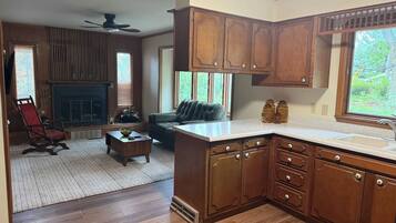 A kitchen with wooden cabinets, a countertop, and a window.
