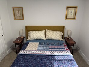 A bedroom with a bed, two nightstands, two wall-mounted lamps, and two framed pictures. - Cozy basement 1B1B apt. in Barnum neighborhood, 10mins from city & mtns (Denver)