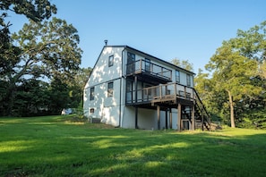 A two-story house with a balcony and a staircase leading to an upper level. - 4BR Modern Farmhouse, Golf Views  Sleeps 10 (Belton)