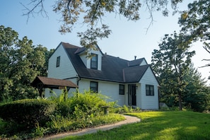 A two-story house with a gabled roof, a front porch, and a well-maintained lawn. - 4BR Modern Farmhouse, Golf Views  Sleeps 10 (Belton)