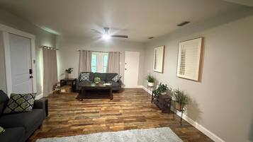 A living room with a sofa, a coffee table, and a white rug.