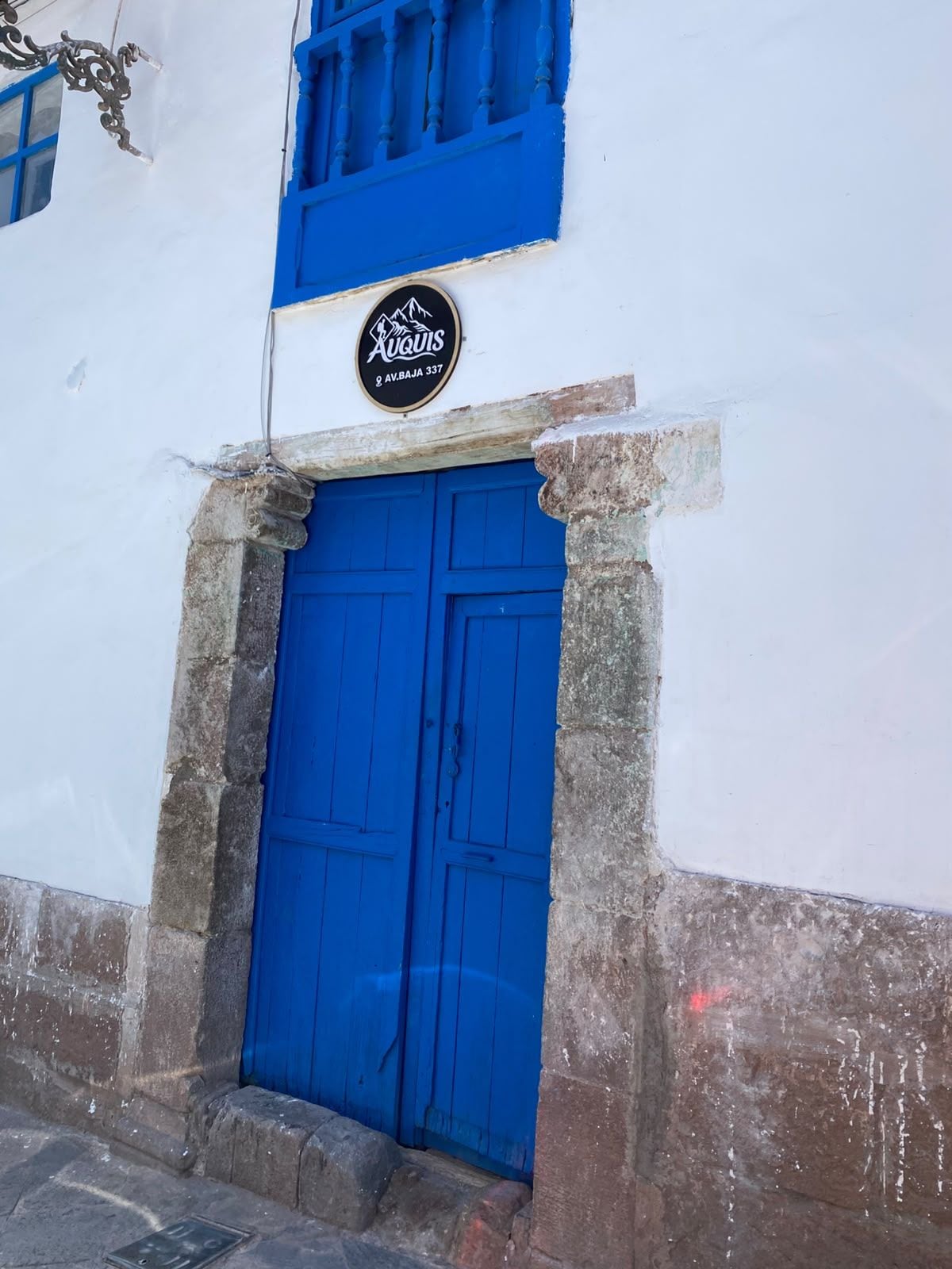 Un edificio con una puerta azul y un letrero encima.