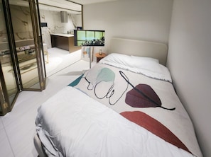 A hotel room with a bed, a bedside table, a TV, and a bathroom with a mirror and toilet. - Gangnam/Seocho/Seoul Univ - Cozy 2-Bedroom Apartment with AC in Vibrant Seoul (Seoul)