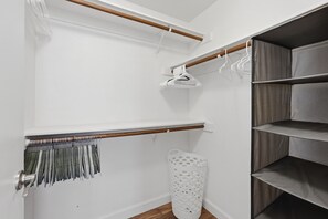 A walk-in closet with wooden shelves, a drying rack, and a storage bin. - Charming Gilbert Home: Primary Suite, Flex 2nd BR/Office, Near Park & Downtown (Gilbert)