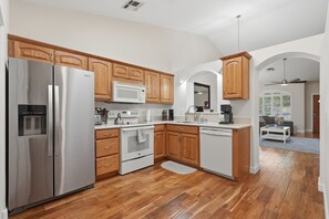 A modern kitchen with stainless steel appliances, wooden cabinets, and a central island. - Charming Gilbert Home: Primary Suite, Flex 2nd BR/Office, Near Park & Downtown (Gilbert)