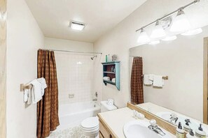 Ein Badezimmer mit einer Badewanne, Toilette und Waschbecken.